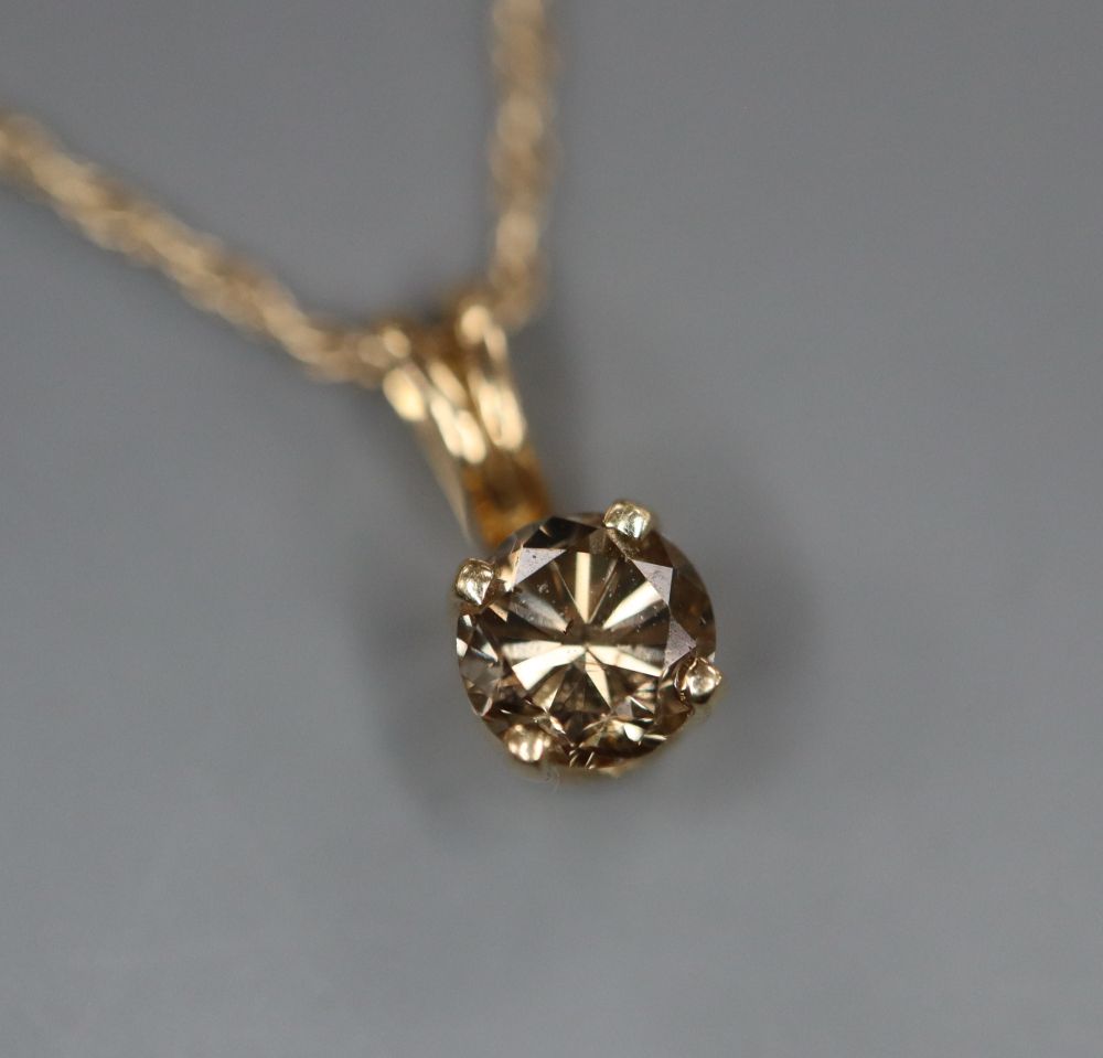 A 10k and chocolate coloured round brilliant cut solitaire diamond pendant, on a 10k fine link chain.